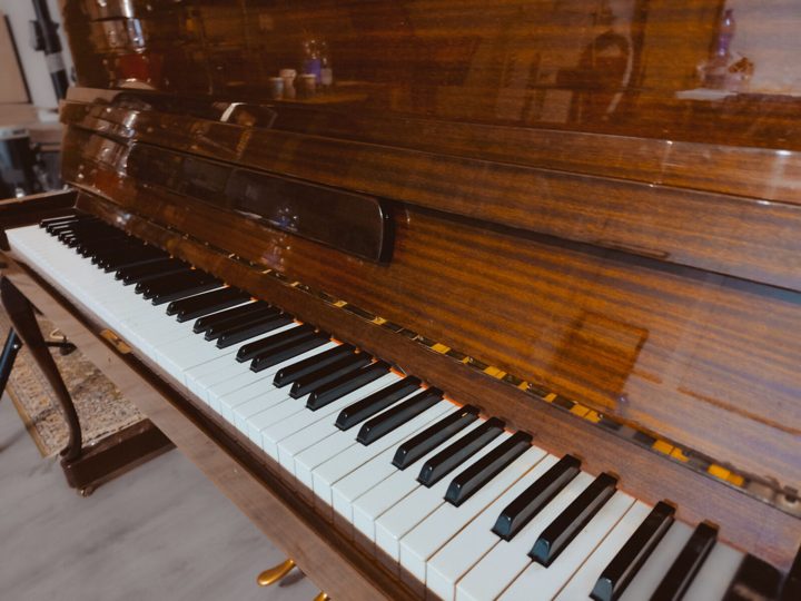 The upright piano's keyboard and polished mahogany case